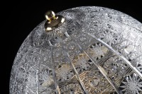 Detail krajkového brusu na skleněném stínidle dekorativní lampy.