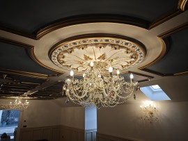 Luxusně zařízené nízké prostory v podkroví domu s barevnými křišťálovými lustry